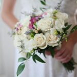 A beautiful bridal bouquet featuring white and pink roses, perfect for a wedding ceremony.